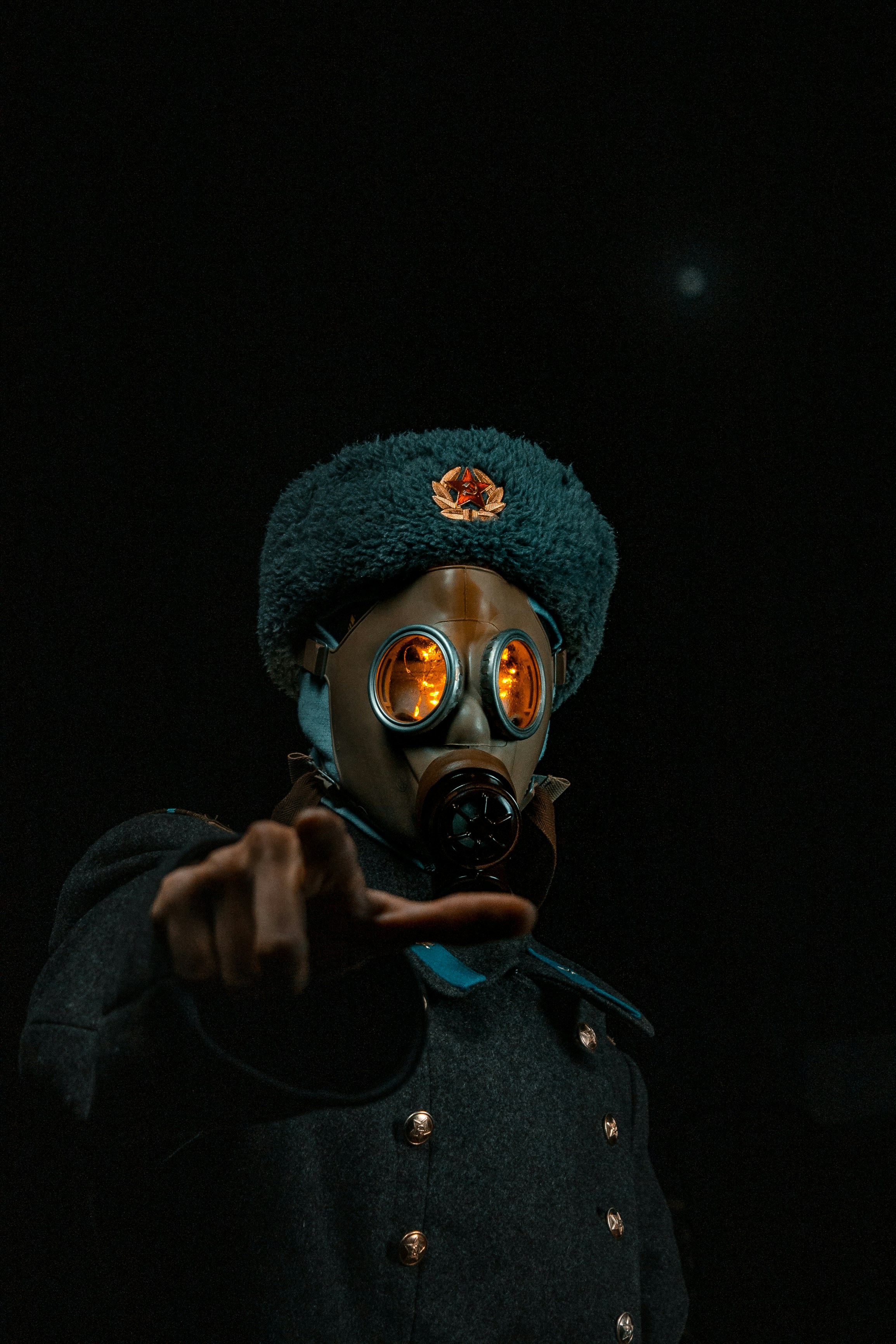 a man in a gas mask pointing at the camera