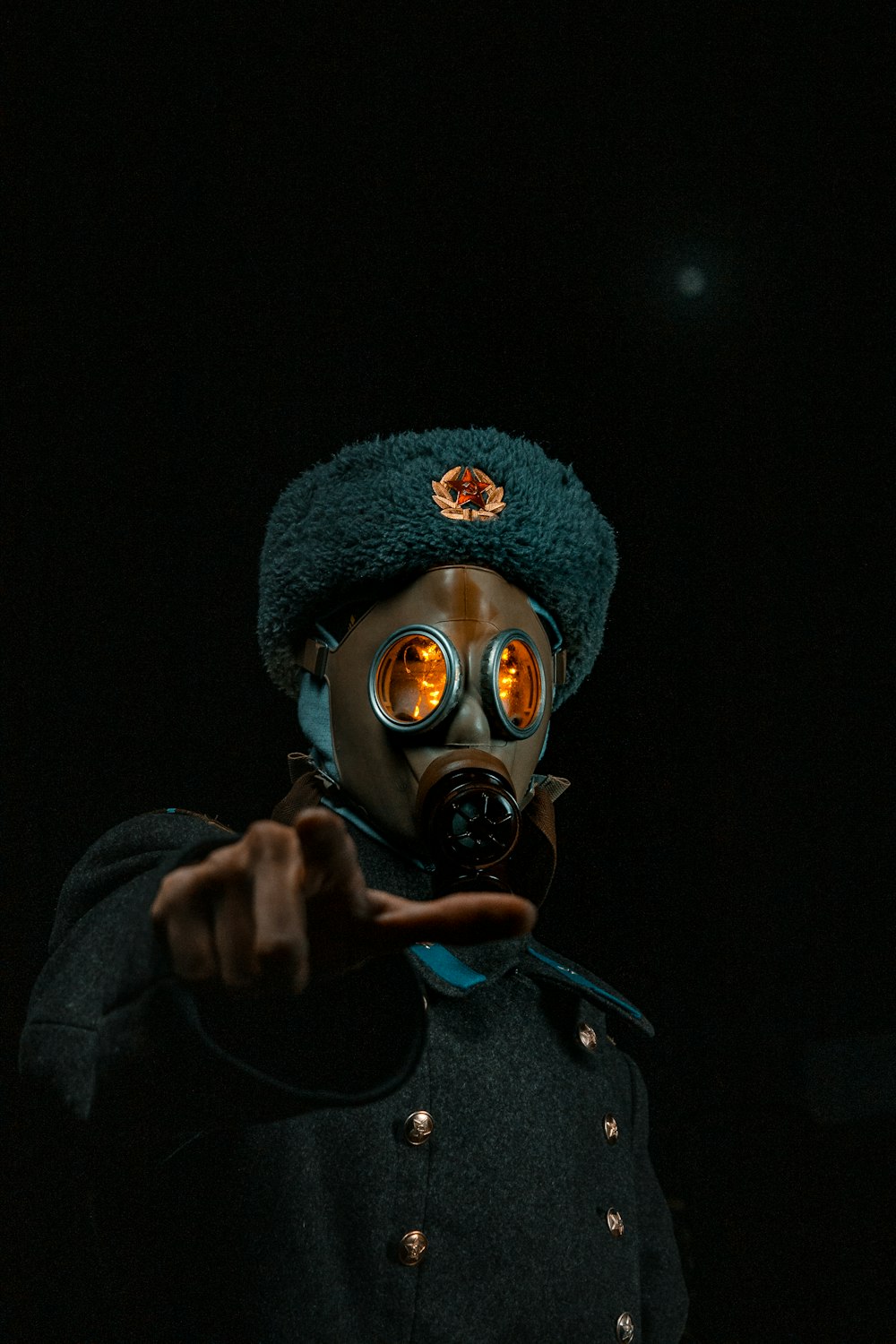 a man in a gas mask pointing at the camera