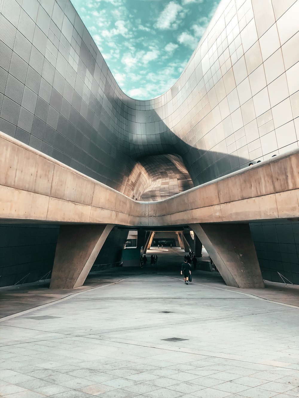 a person standing in a parking garage under a blue sky