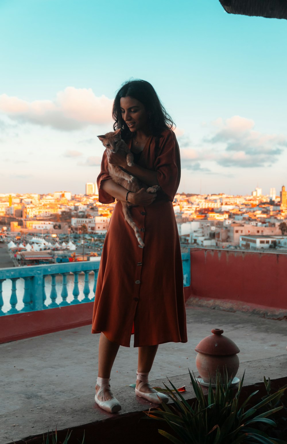 a woman in a red dress holding a cat