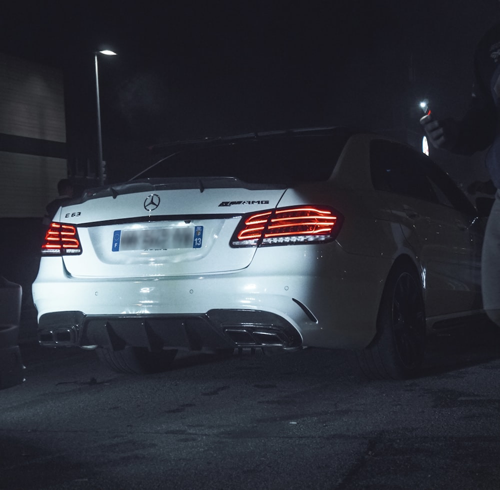 a white car parked in a parking lot at night