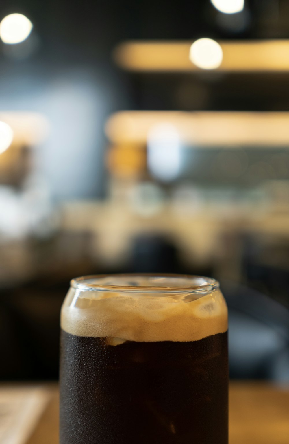 a glass of beer sitting on top of a wooden table