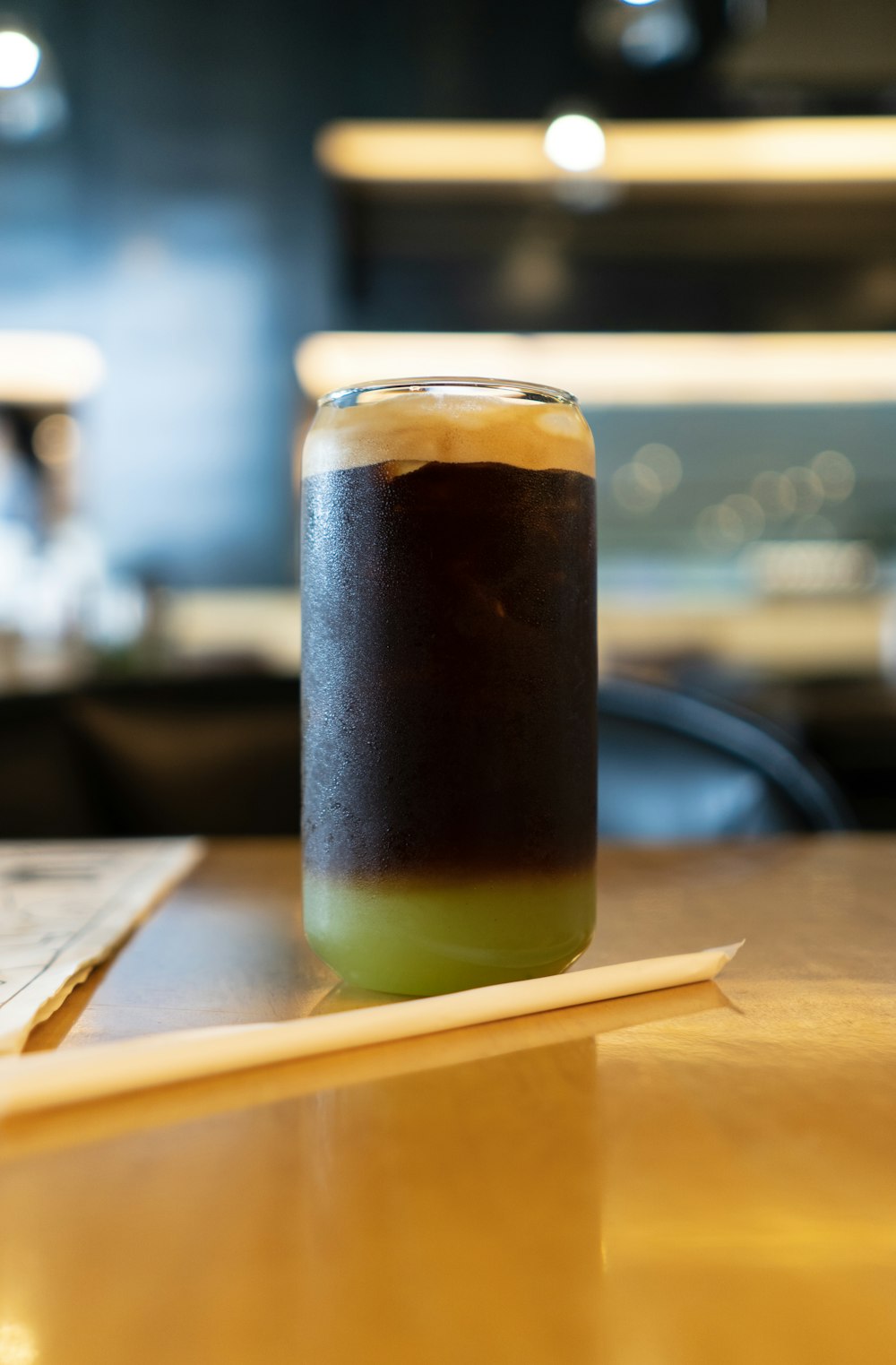 a glass of beer sitting on top of a wooden table