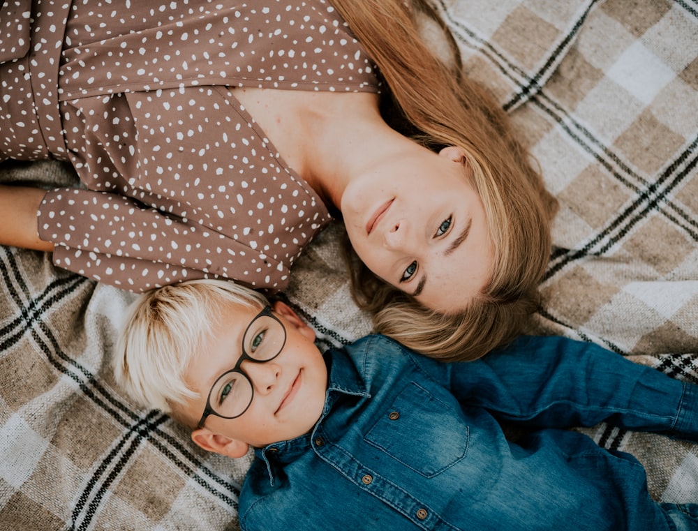 a boy and a girl laying on a blanket