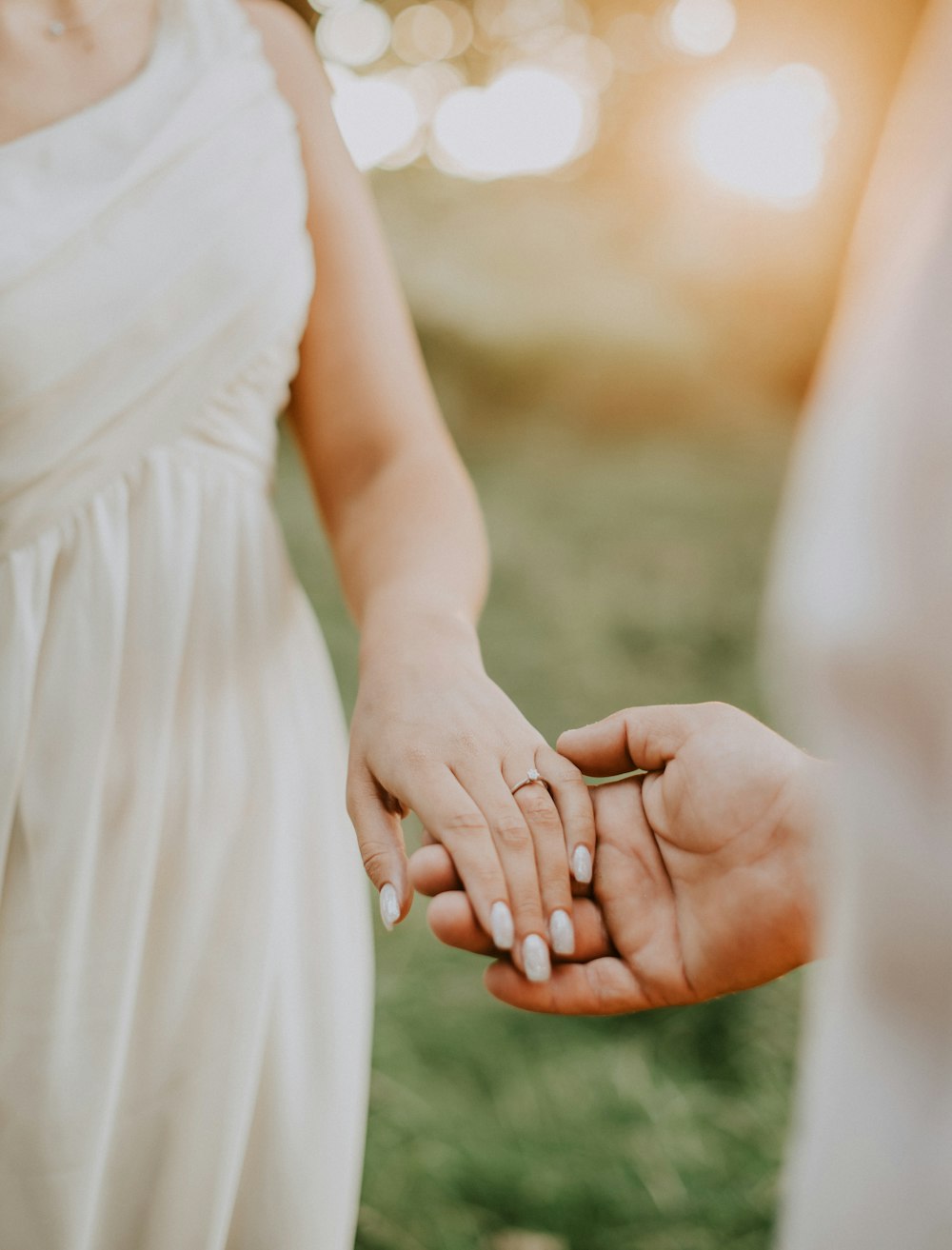 a close up of two people holding hands