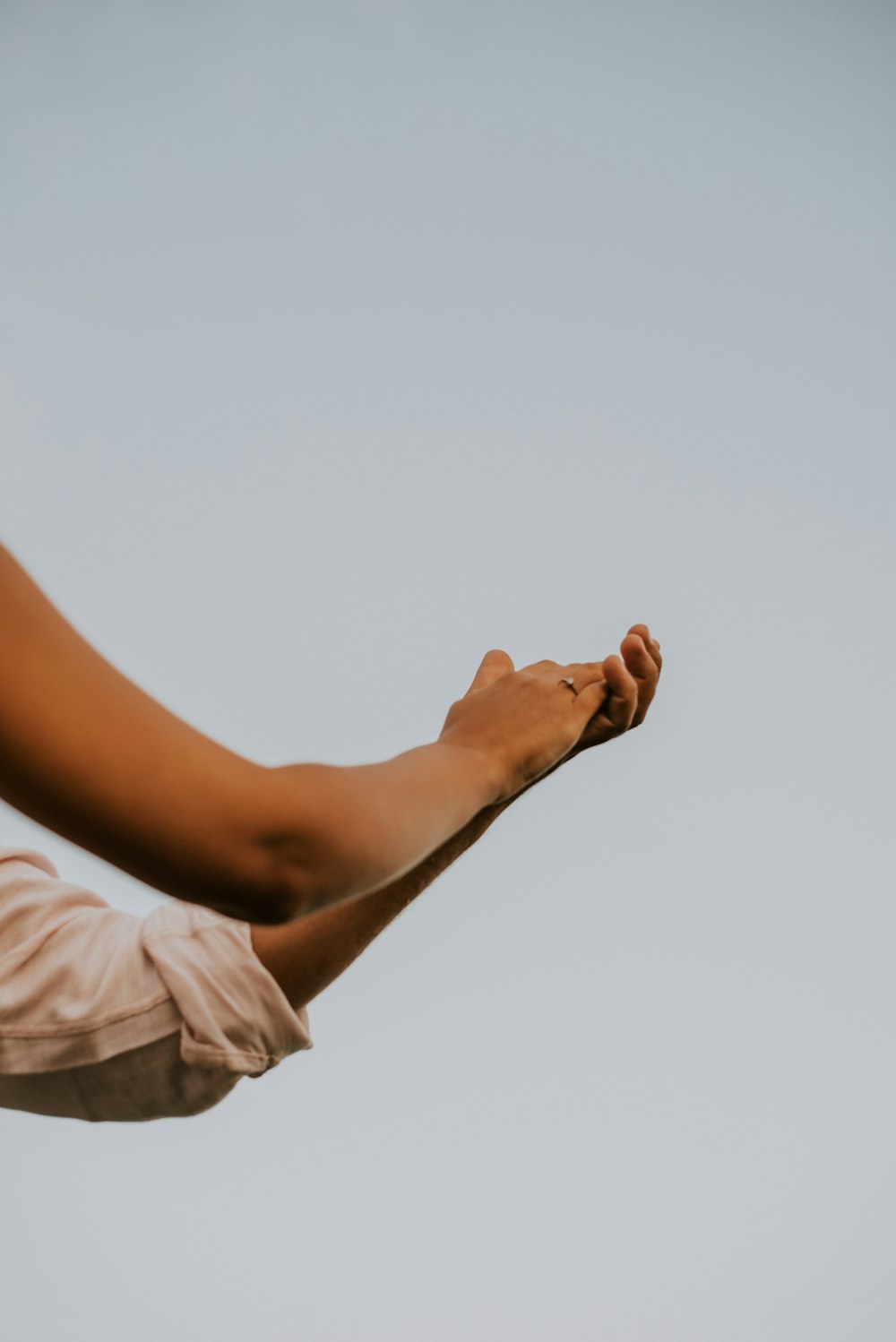 a woman's arm and arm with a sky in the background