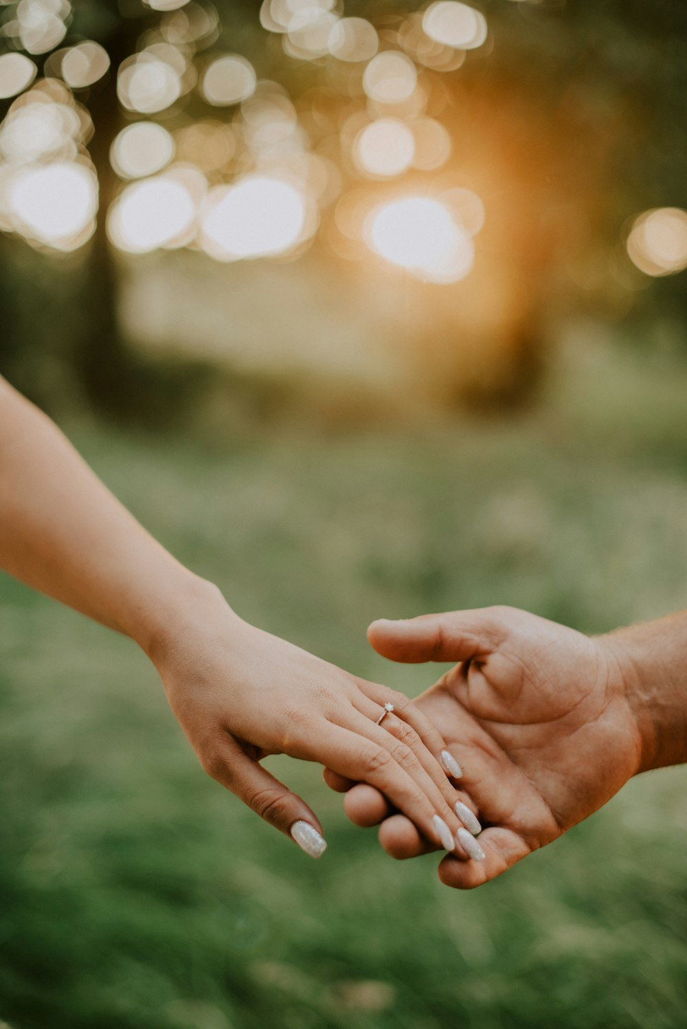 a close up of two people holding hands