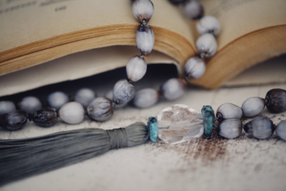 a close up of a book with beads and a tassel