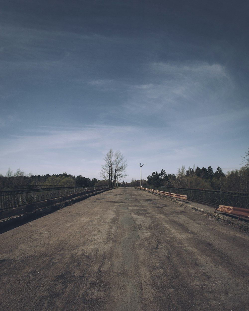 a dirt road with benches on the side of it