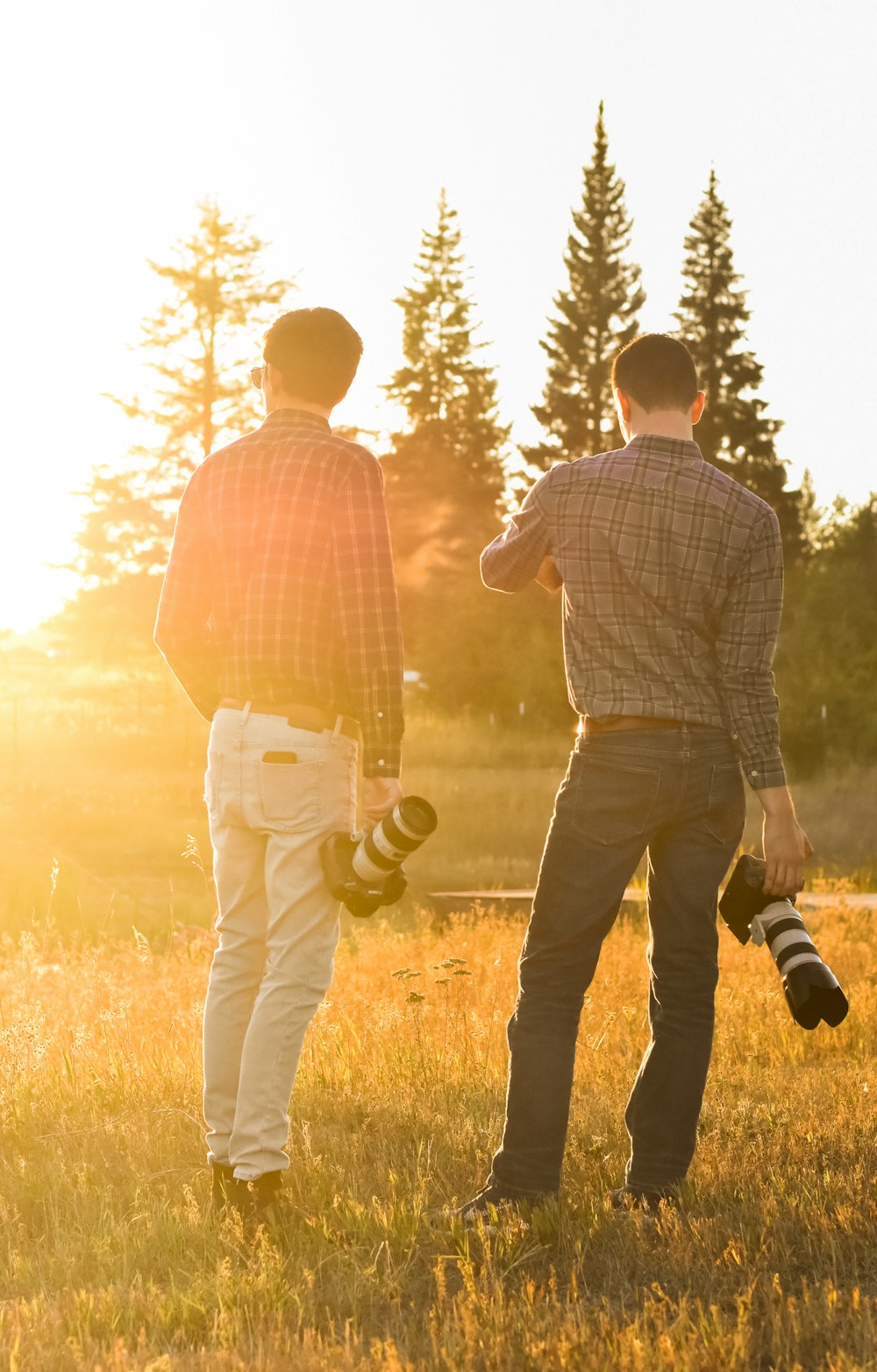 a couple of men standing on top of a grass covered field