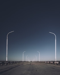 an empty road with several street lights on each side