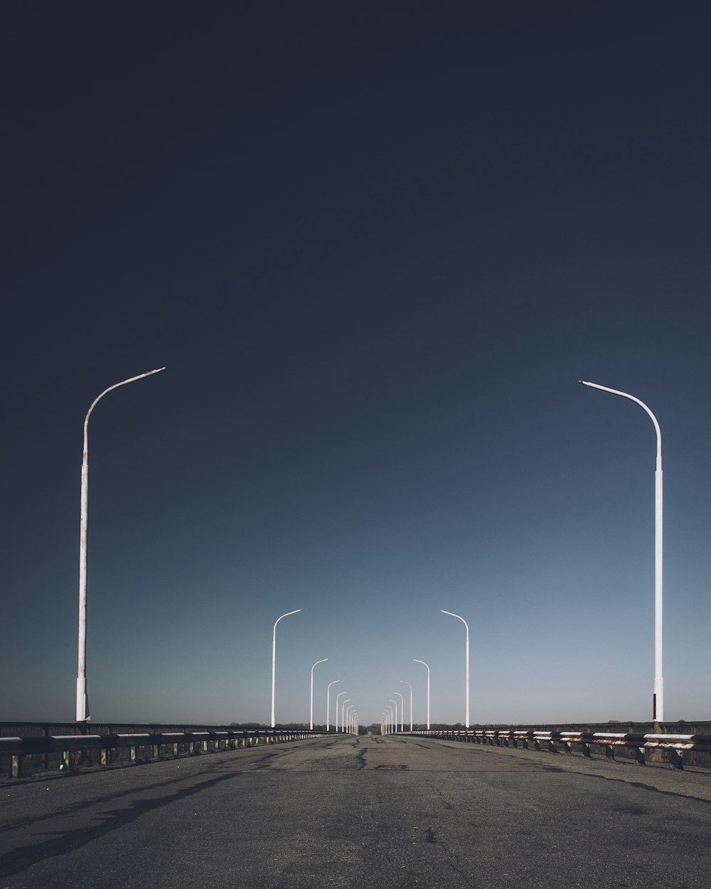 an empty road with several street lights on each side