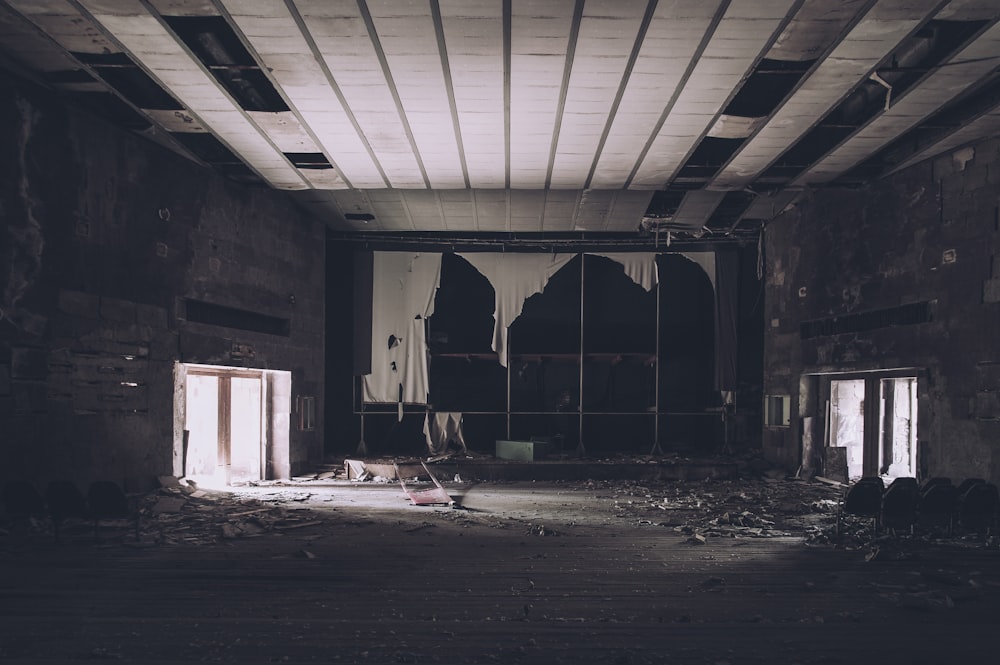 an abandoned building with broken windows and debris on the floor