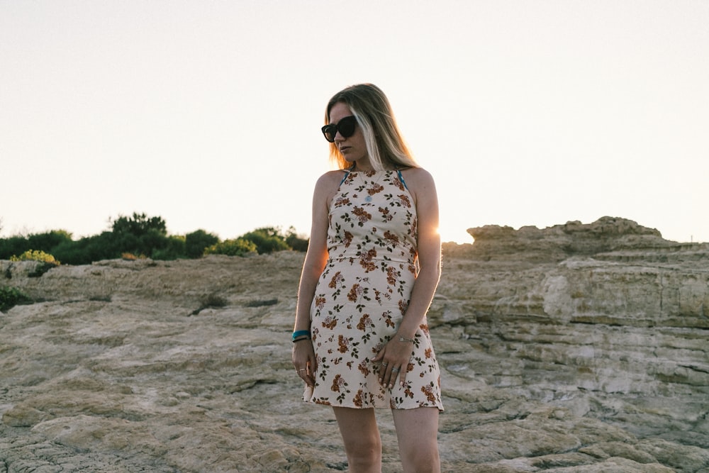 a woman standing on top of a rocky hillside