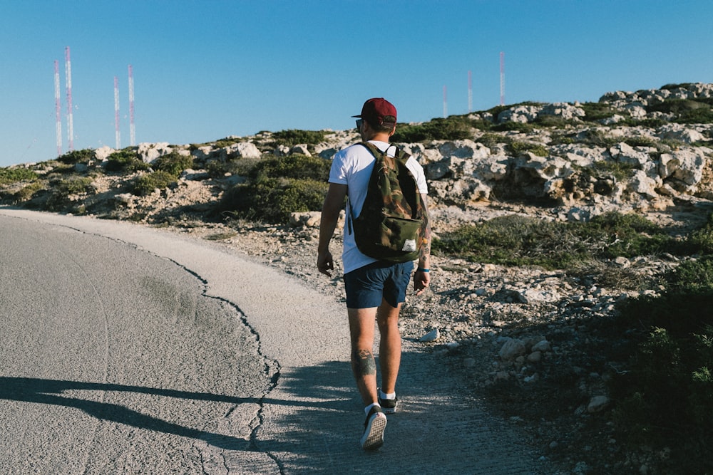 a man with a backpack walking down a road