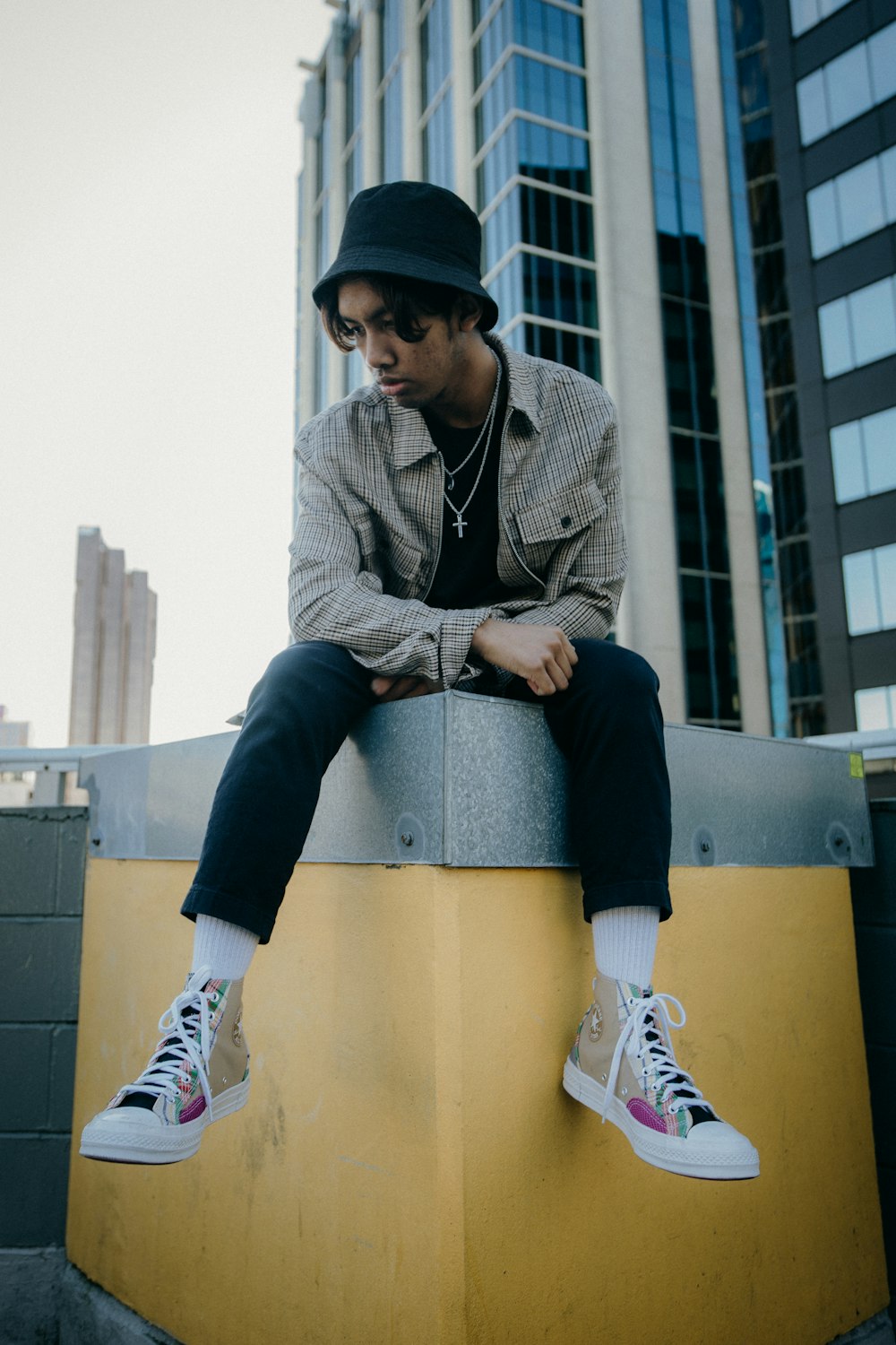 a man sitting on top of a yellow wall