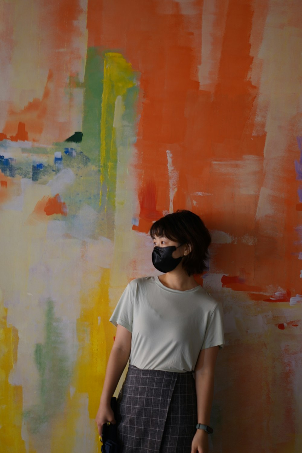 a woman standing in front of a colorful wall