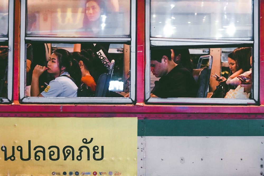 a group of people sitting inside of a bus