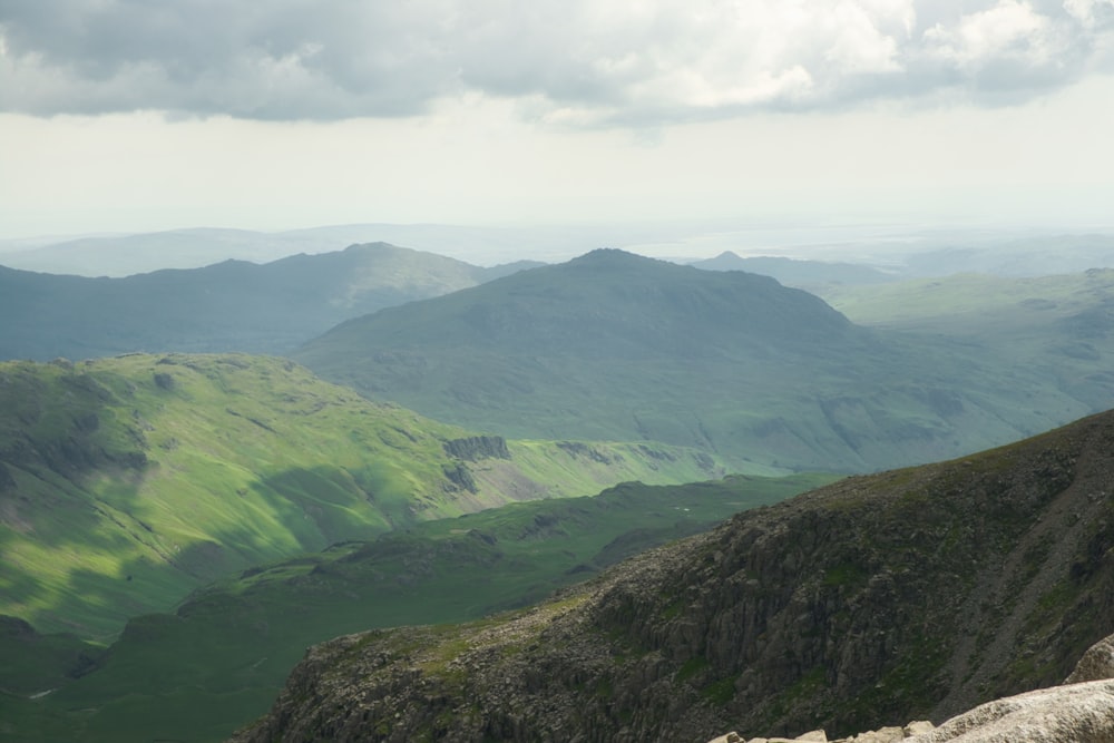 a man sitting on top of a mountain overlooking a valley