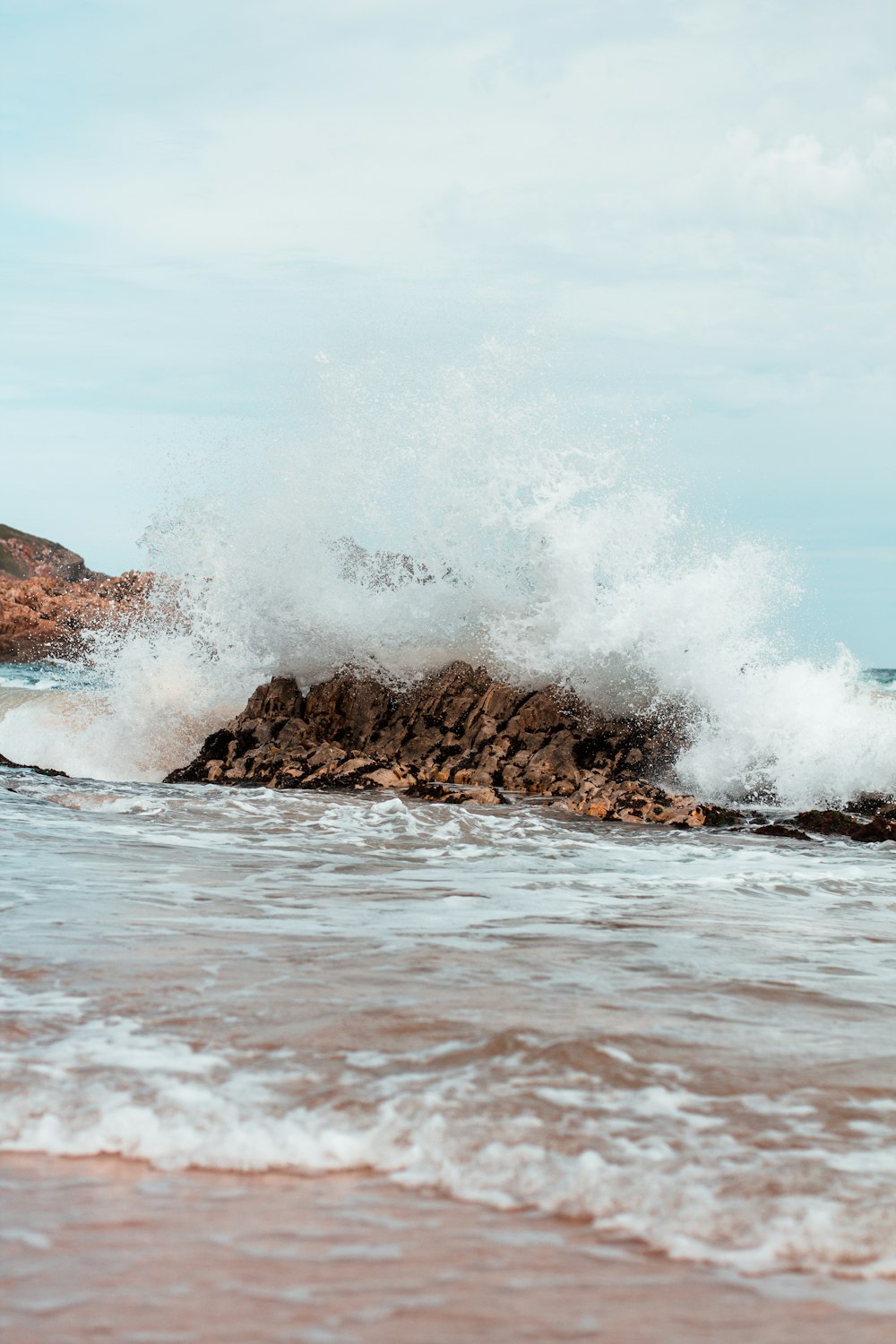Una ola rompiendo contra una roca en el océano