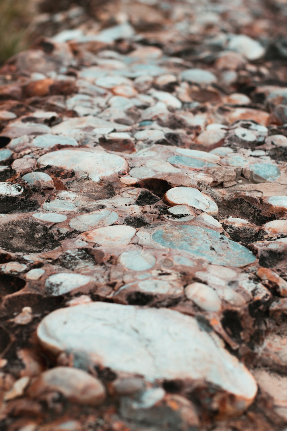 a close up of rocks and dirt with grass in the background