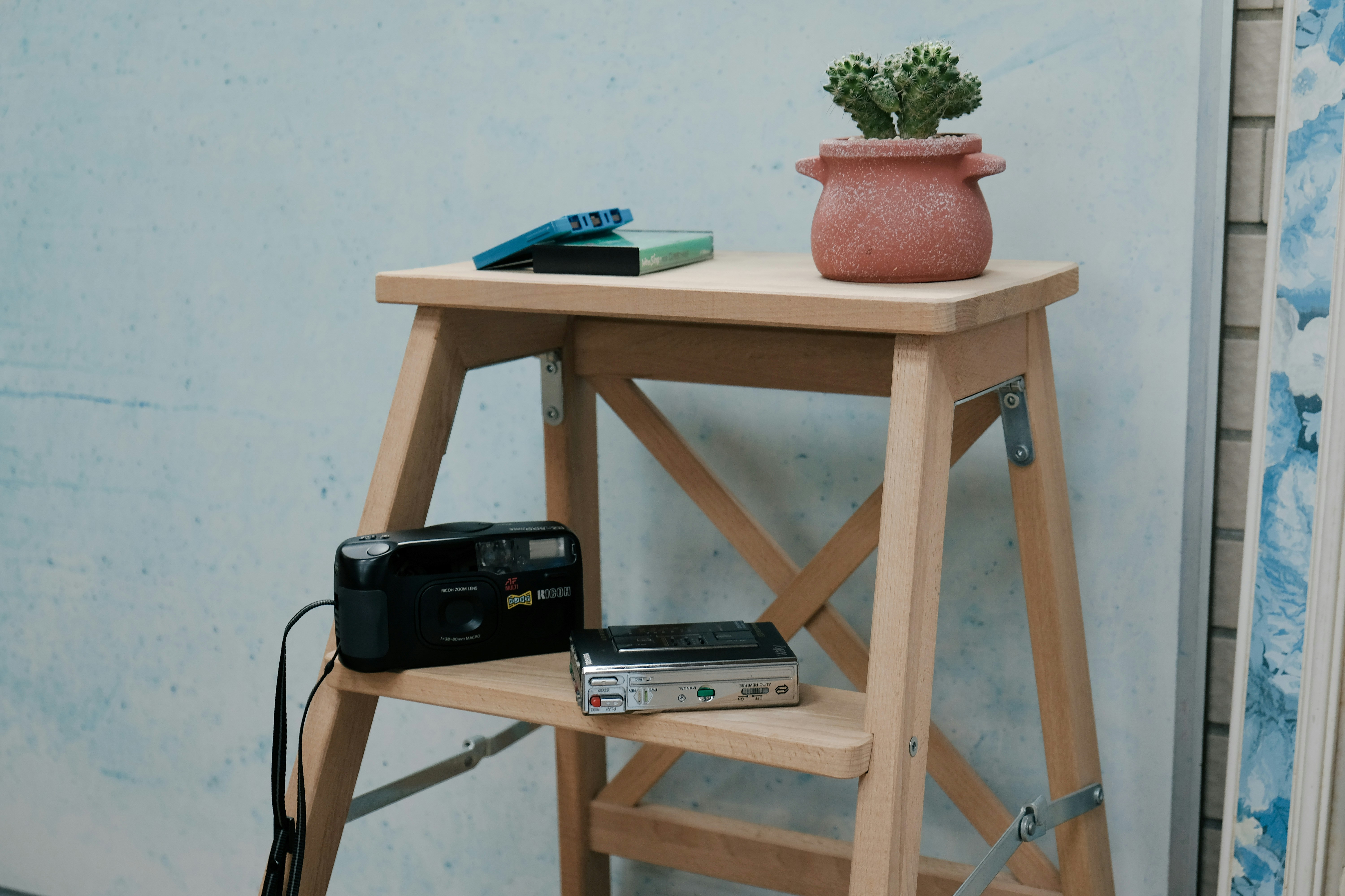 a small table with a camera and a cell phone on it