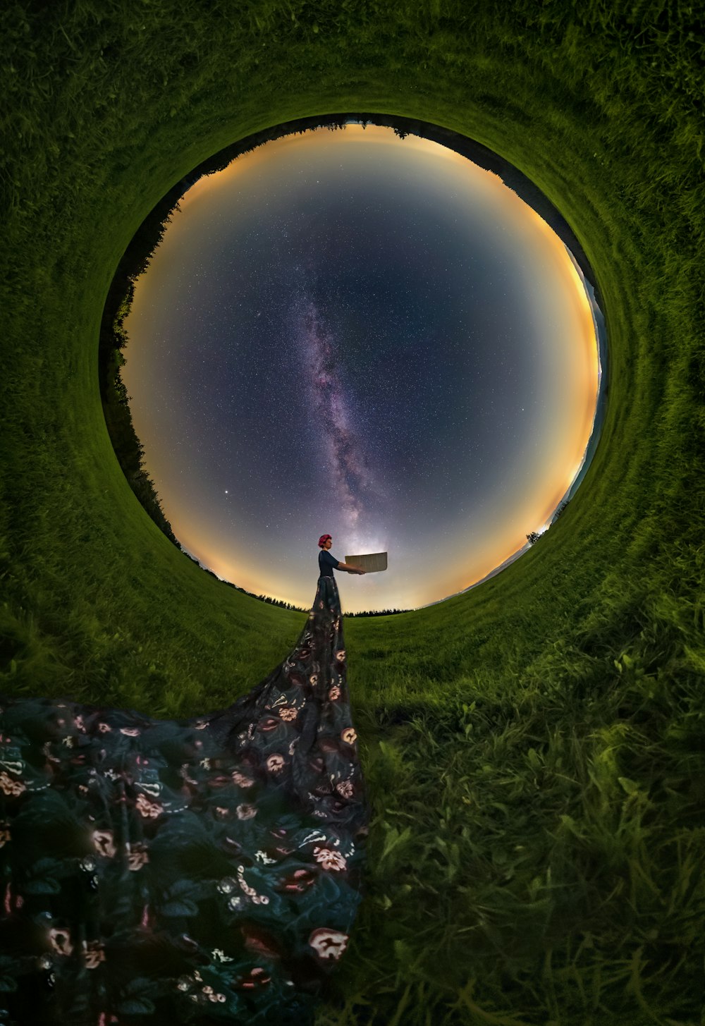 uma pessoa em pé em um campo olhando para as estrelas