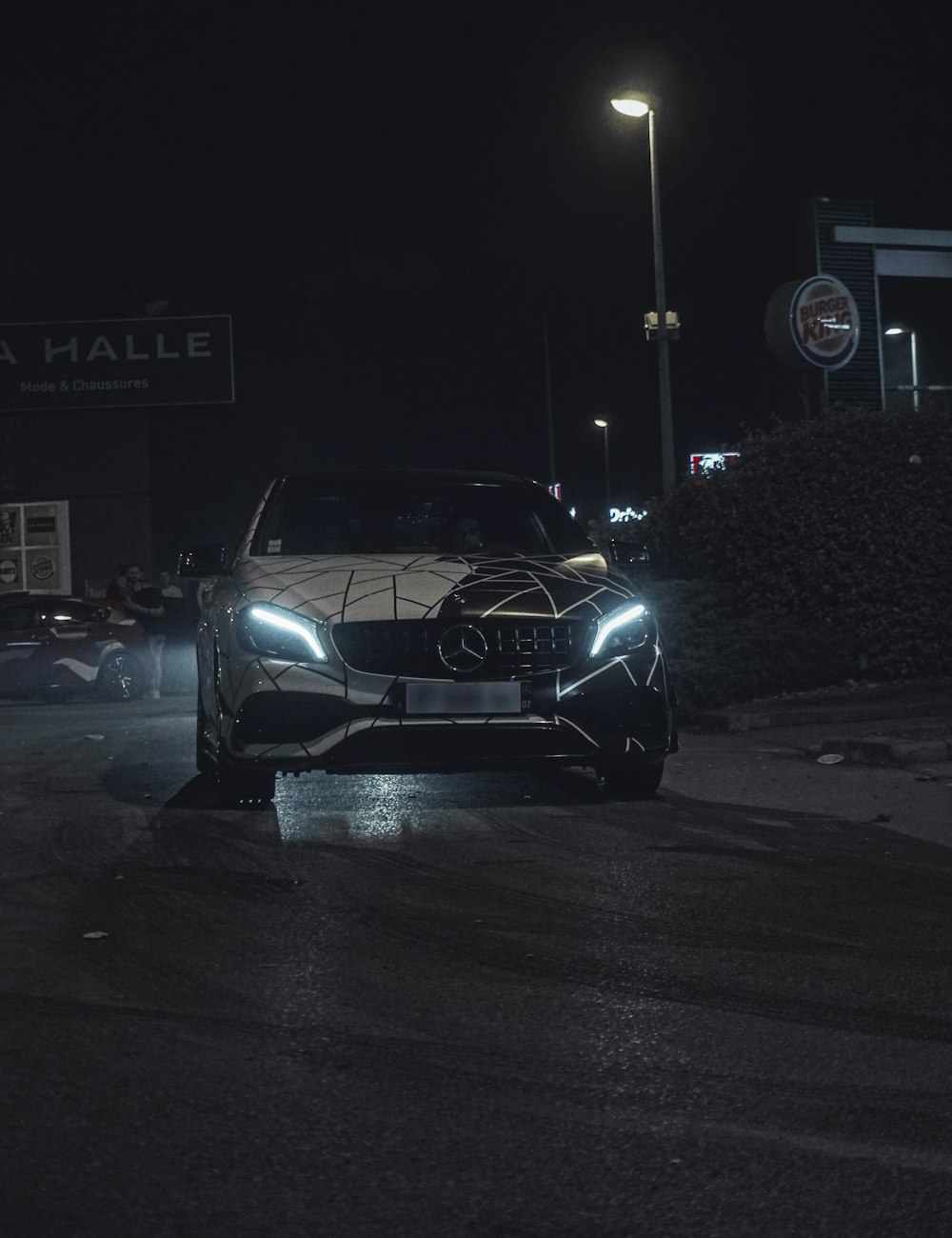 a car driving down a street at night