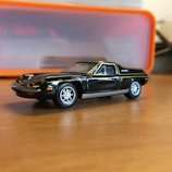 A finished scale model of a futuristic vehicle displayed on a wooden desk