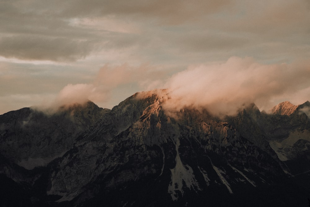 a mountain covered in a cloud covered sky