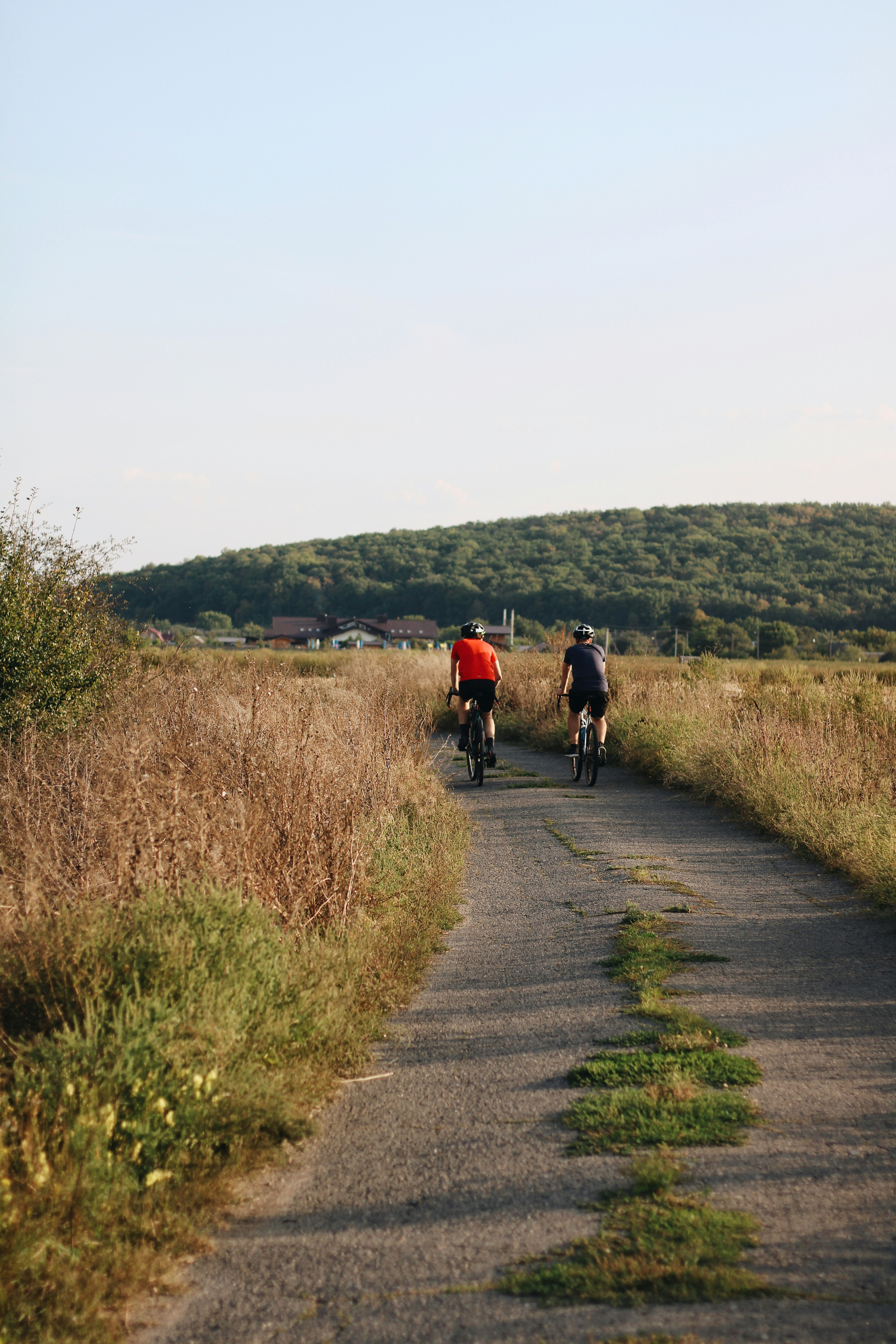 a couple of people riding bikes down a road