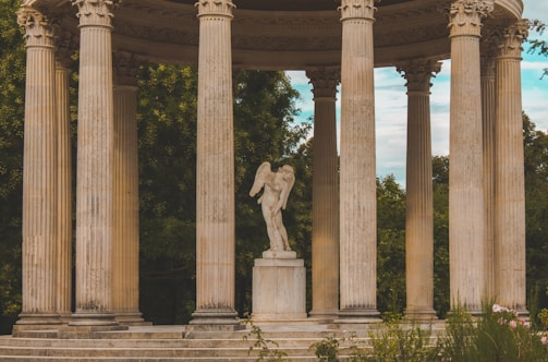 a statue of an angel on a pedestal surrounded by pillars