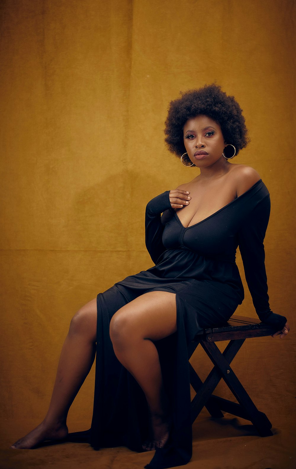 a woman in a black dress sitting on a chair