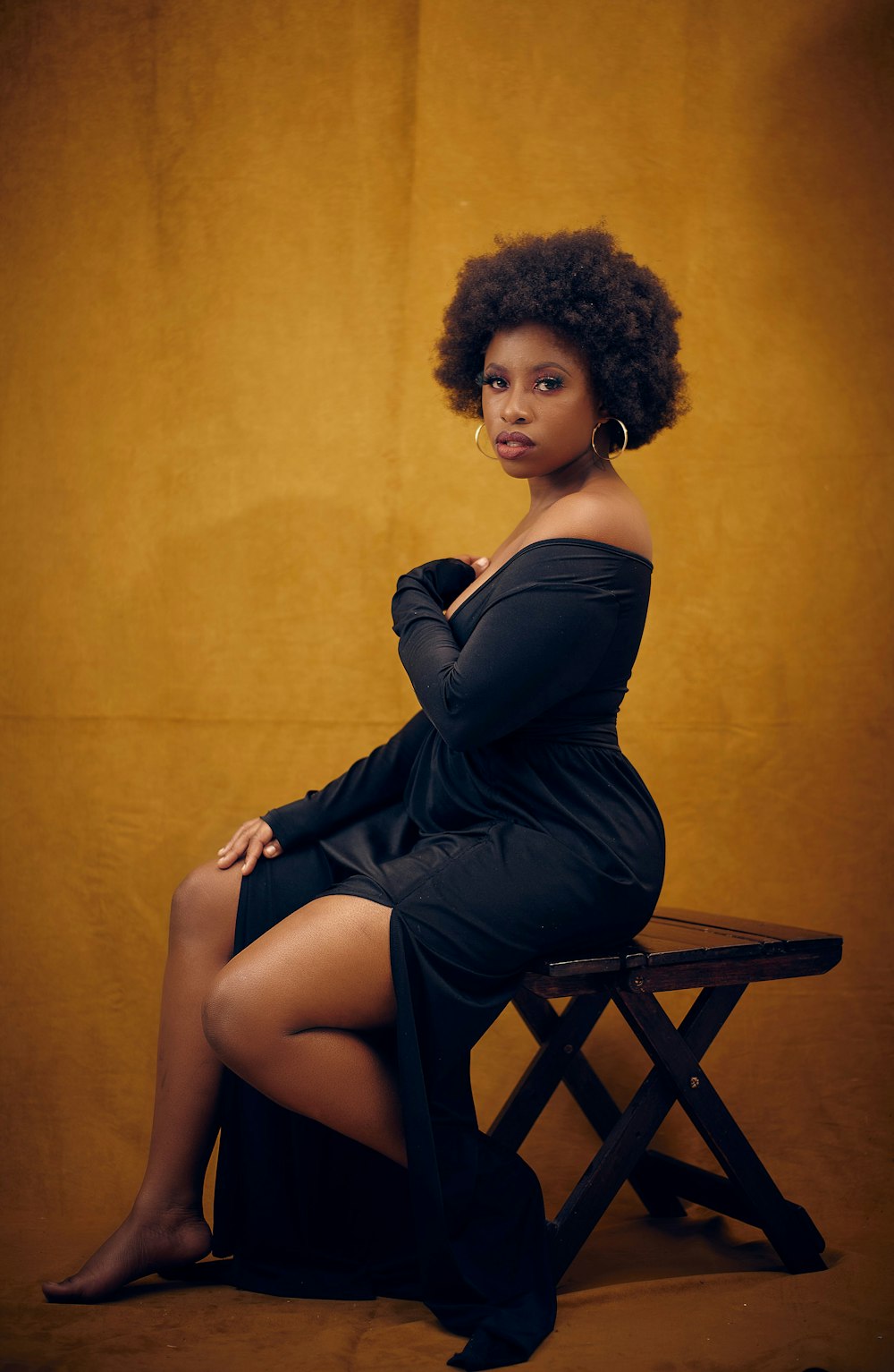 a woman in a black dress sitting on a bench