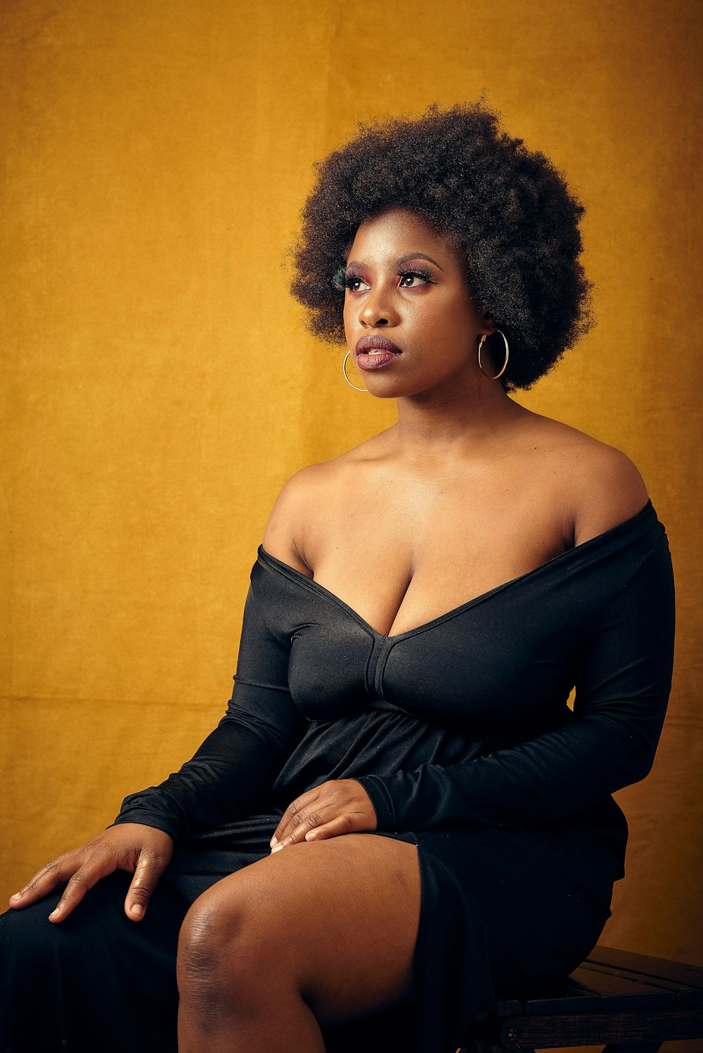 a woman in a black dress sitting on a bench