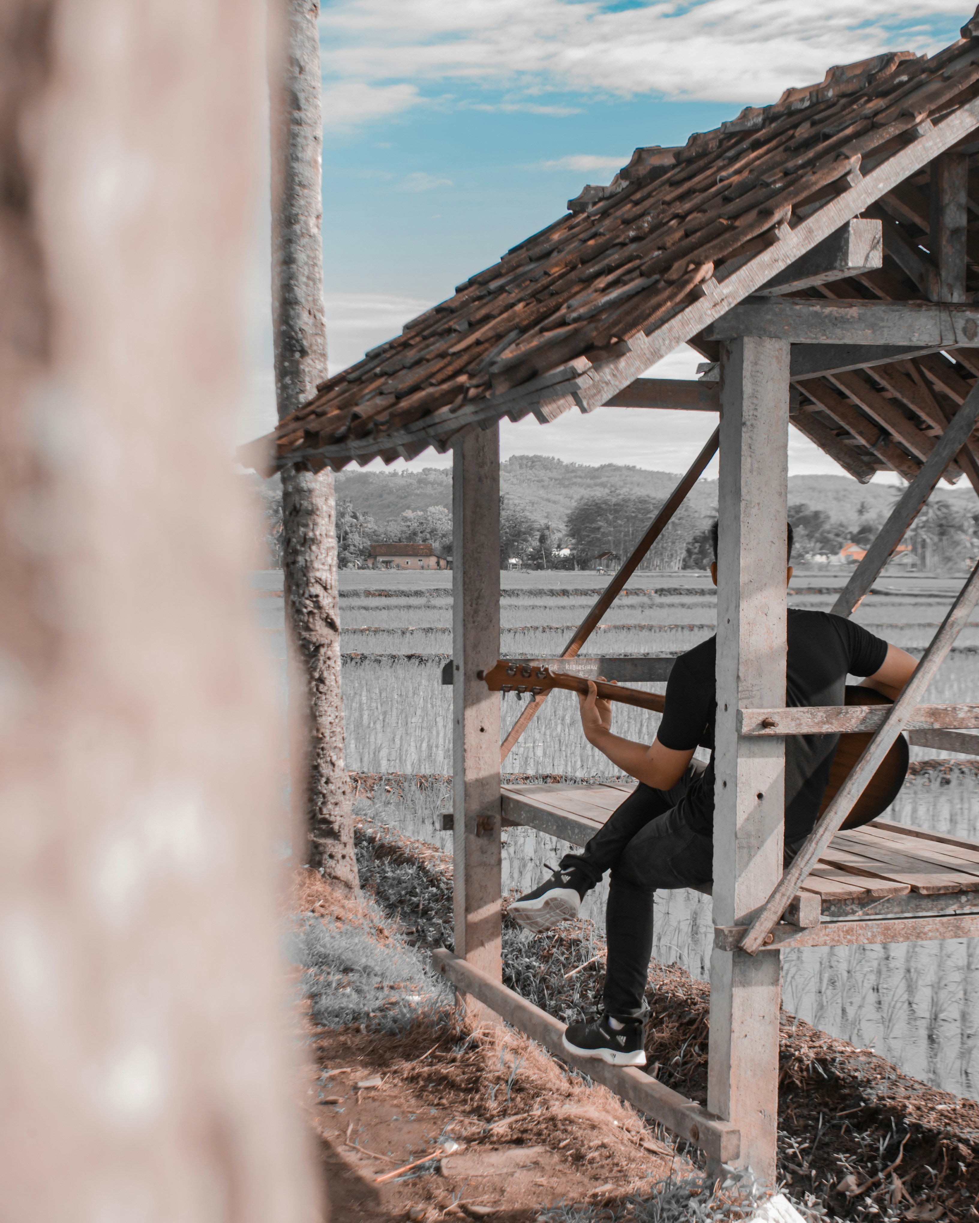 seorang pria duduk di atas struktur kayu