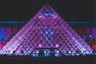 a large pyramid shaped building lit up at night