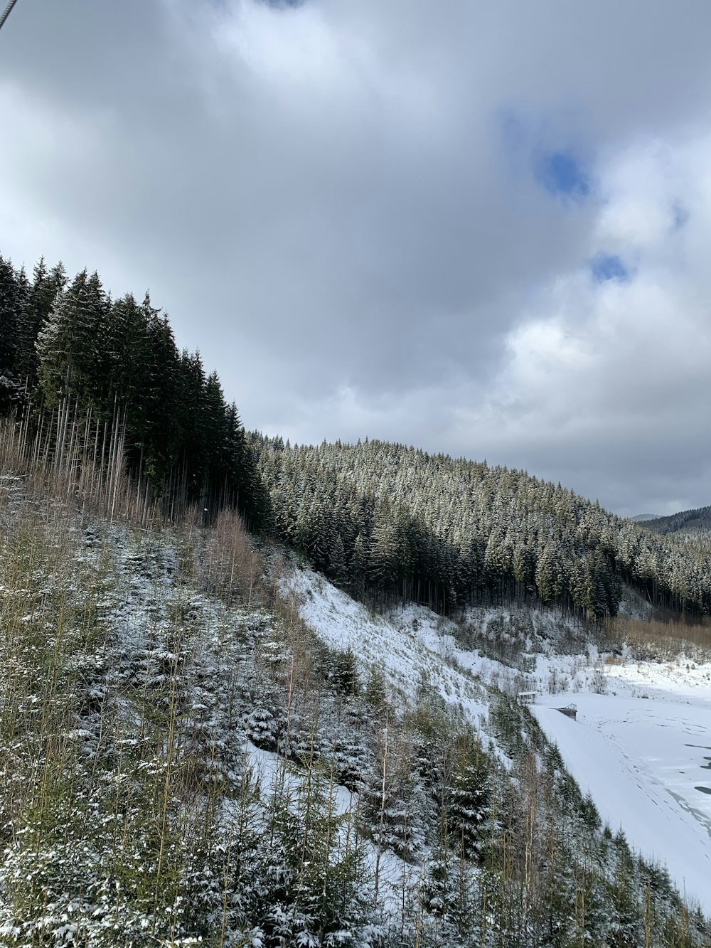 a snow covered hillside with a river running through it