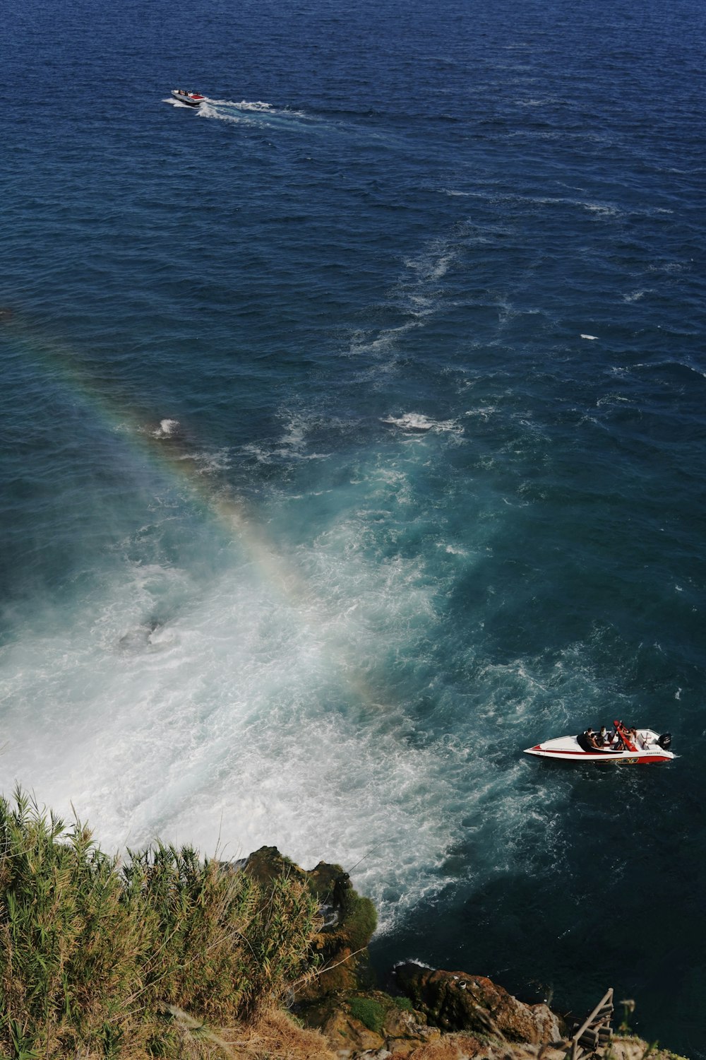 a boat in the water with a rainbow in the background