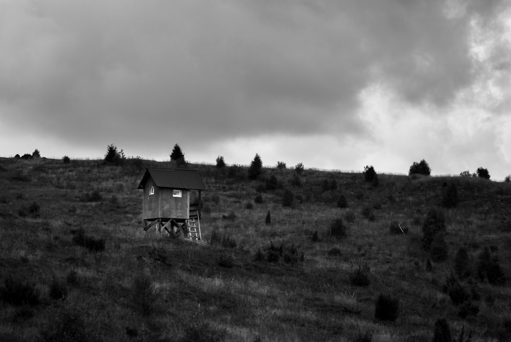 Una foto en blanco y negro de una casa en una colina