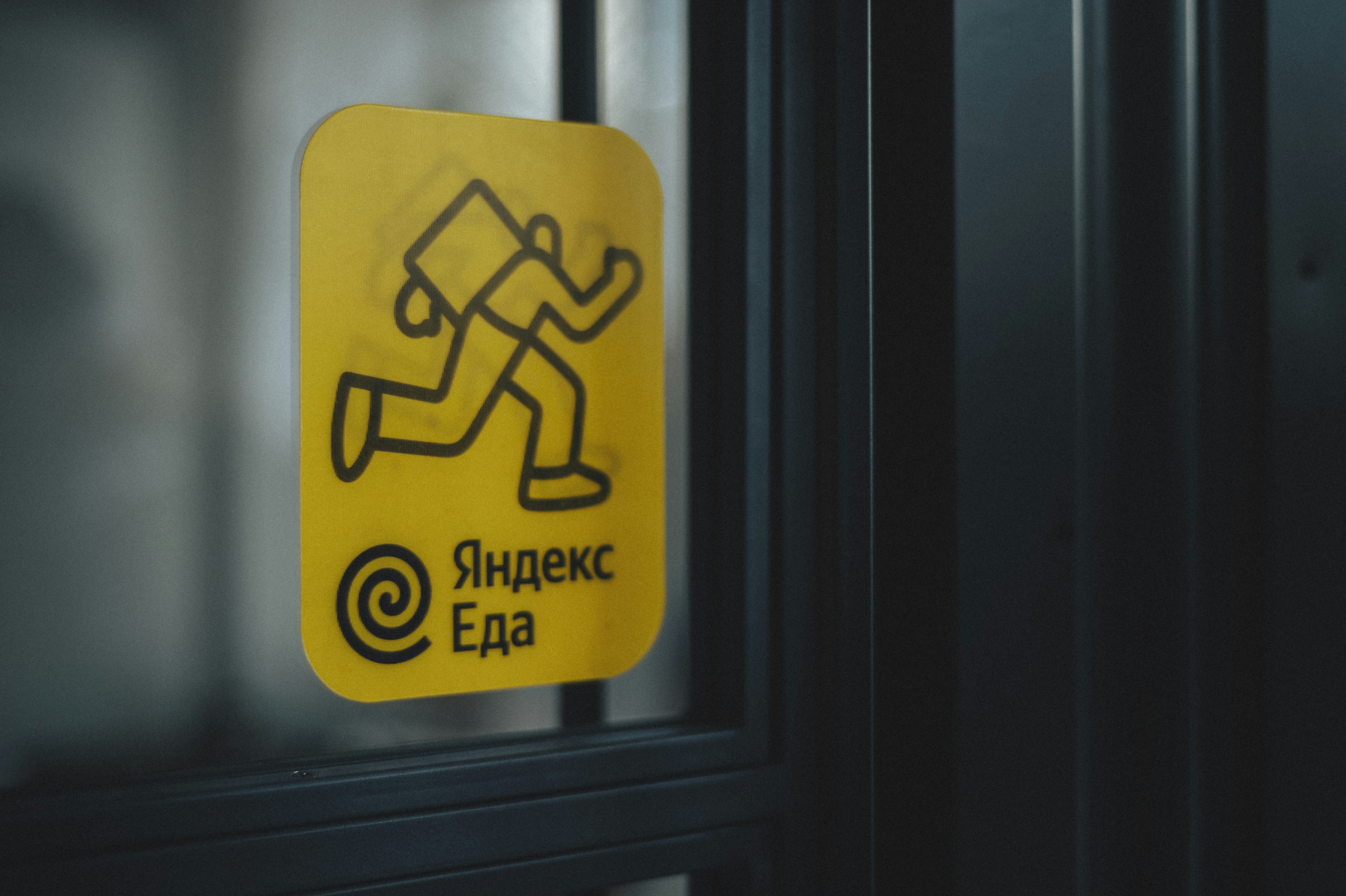 Yandex Food service sticker on the door of the restaurant.