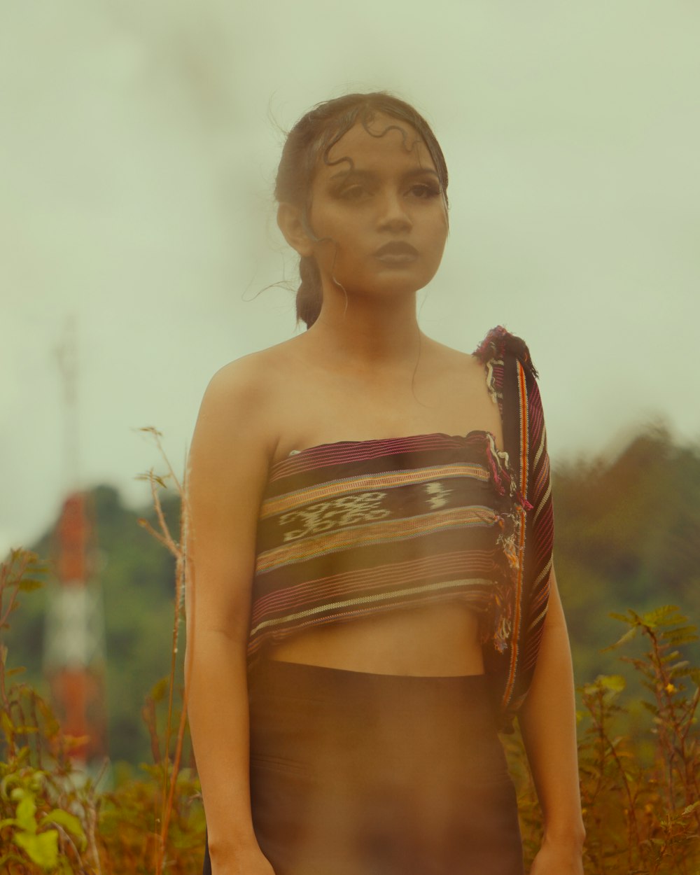 a woman in a bathing suit standing in a field