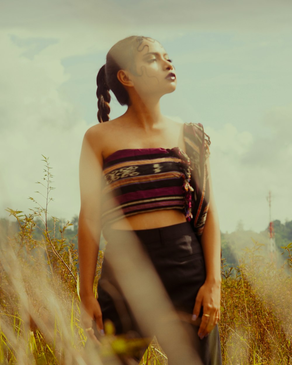 a woman standing in a field of tall grass