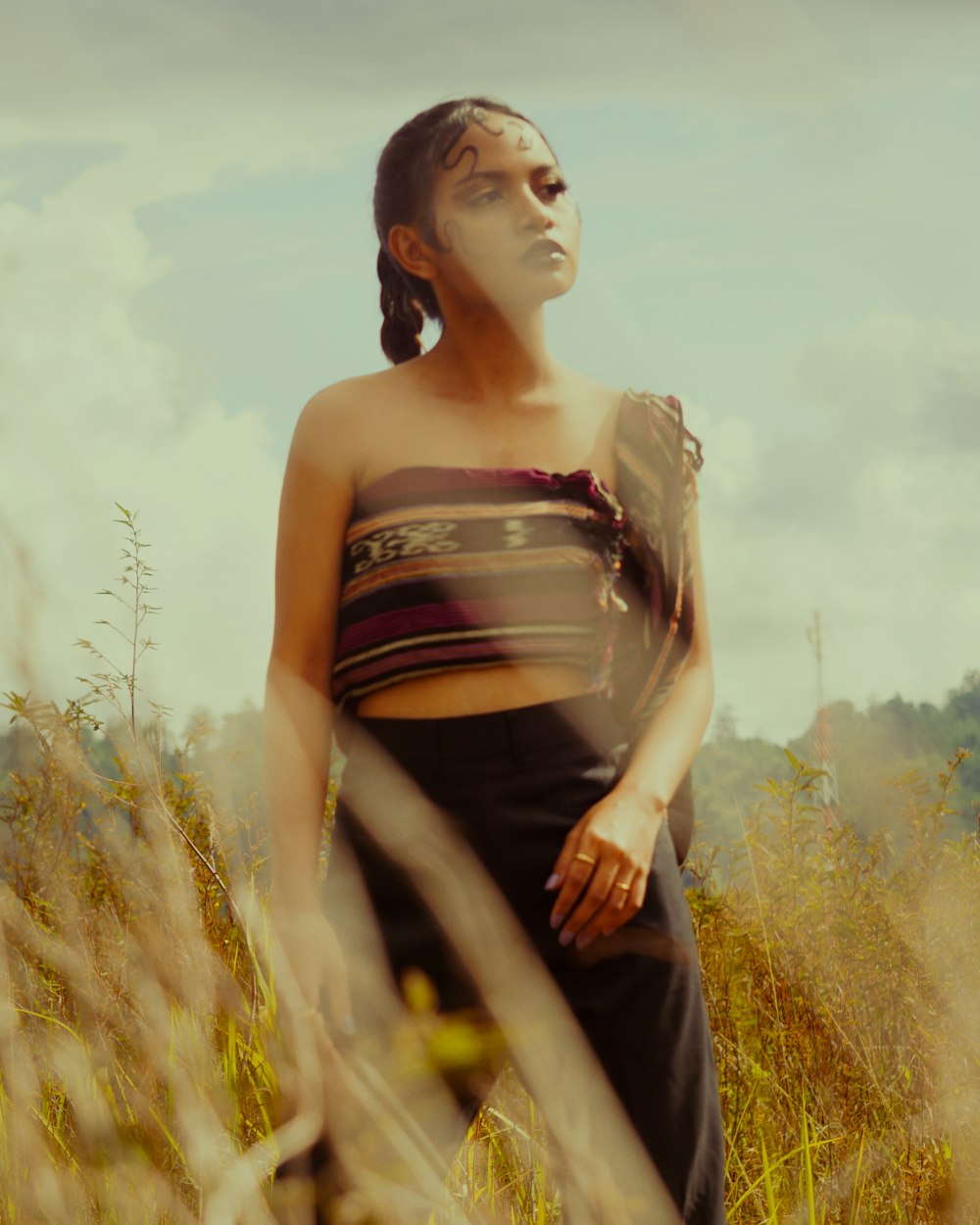 a woman standing in a field of tall grass