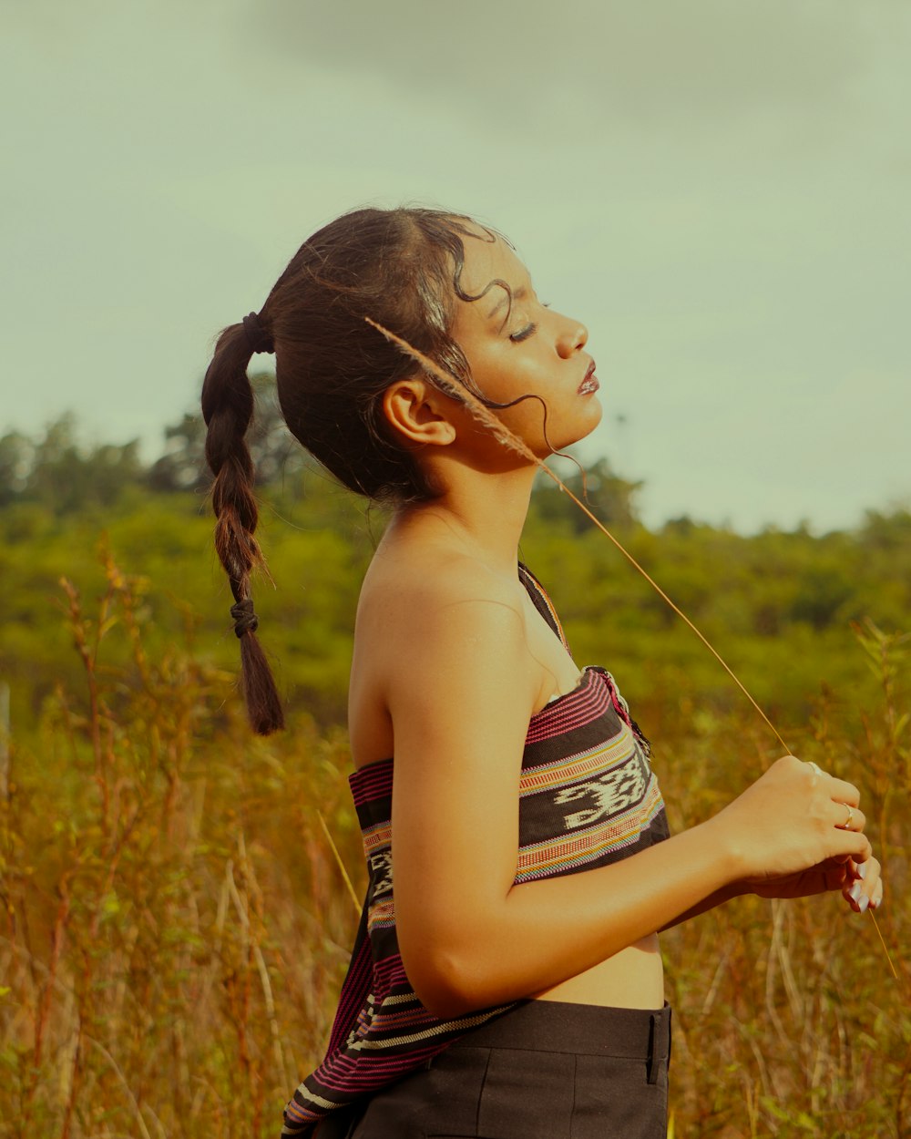 a woman standing in a field of tall grass