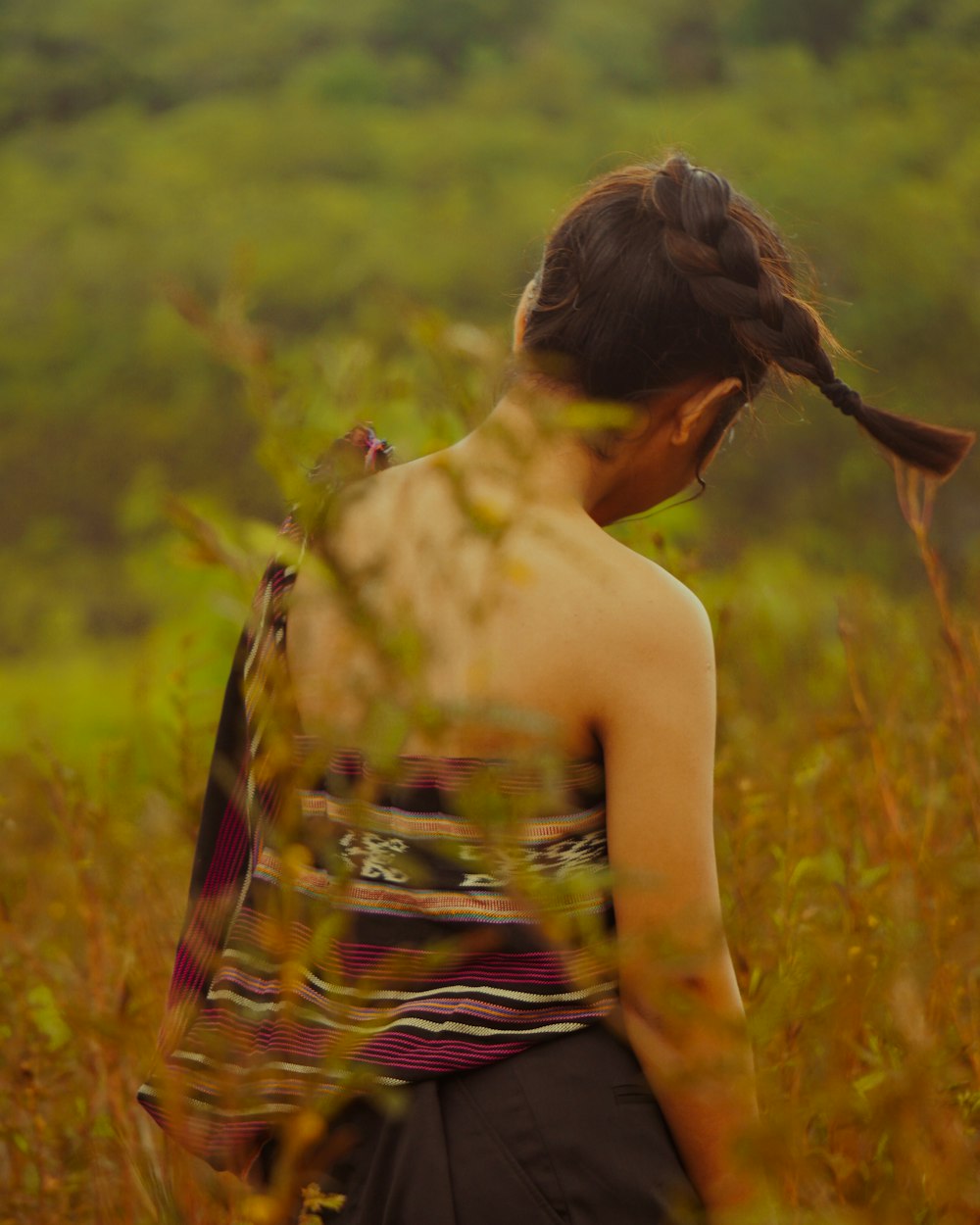 a woman standing in a field of tall grass