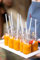 a person holding a tray of orange juice