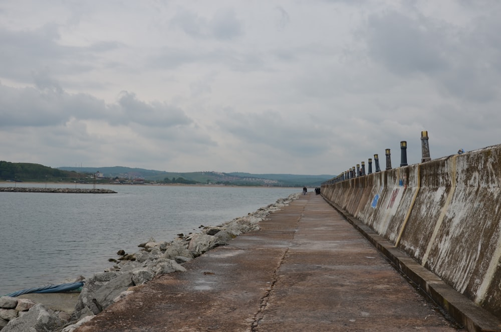 a concrete wall next to a body of water