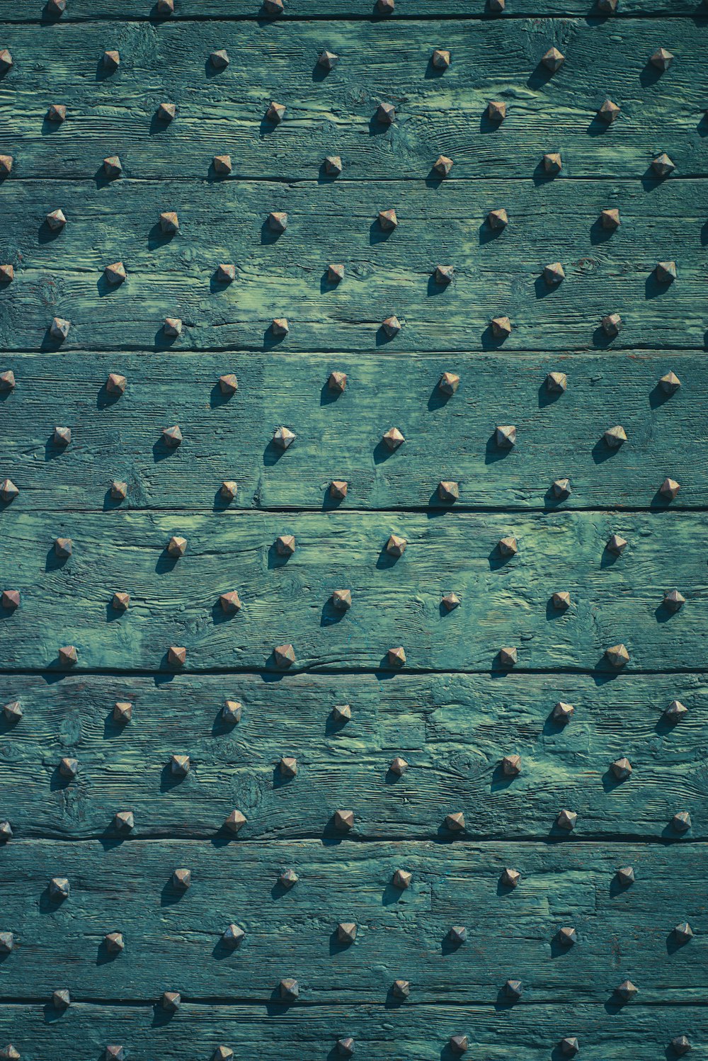 a close up of a wooden surface with rivets