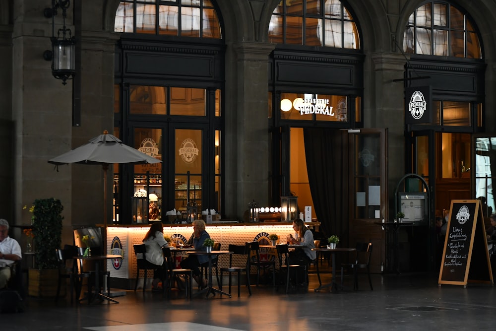 a group of people sitting at tables in front of a building